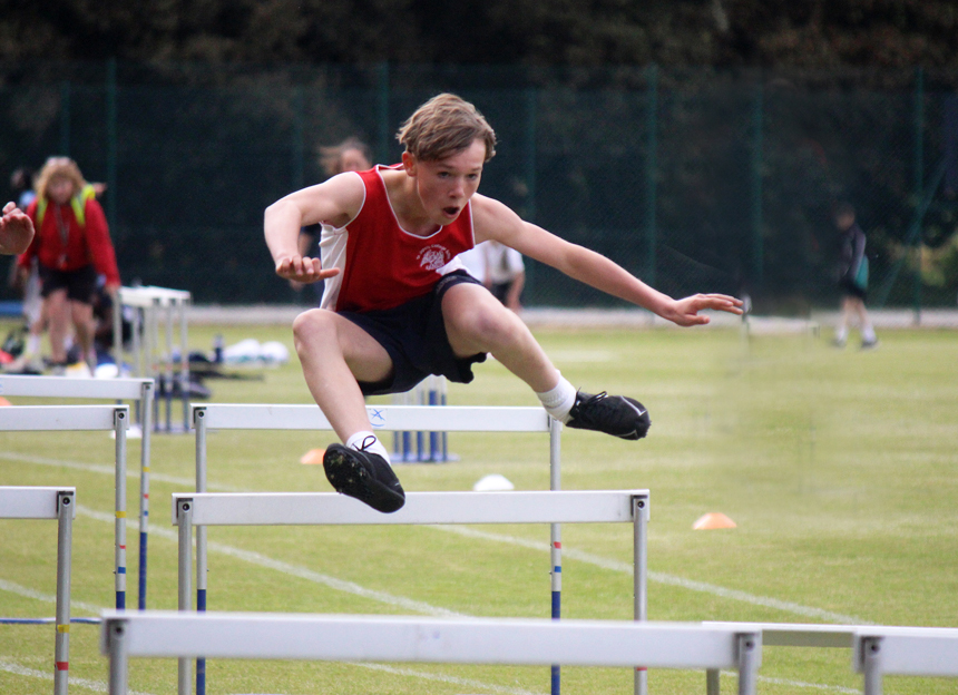 boy jumping over a hurdle