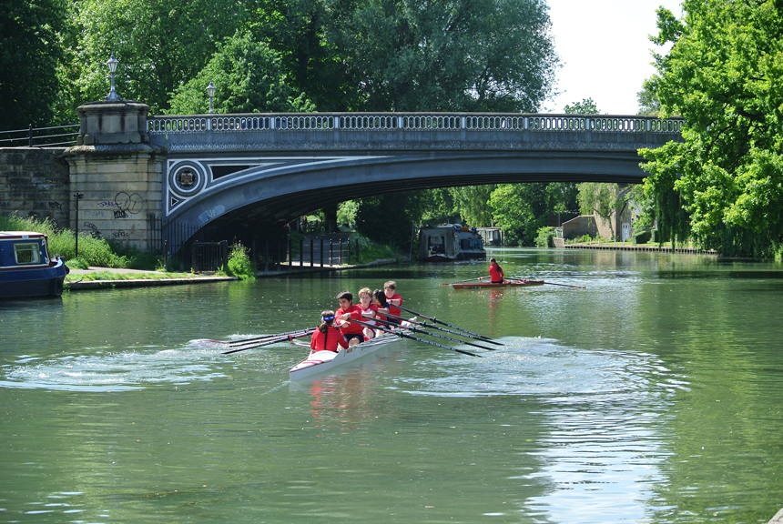 children rowing in a boat on a river
