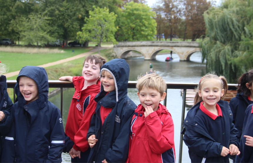 children on a bridge above a river