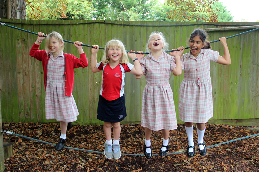girls playing on a rope outside