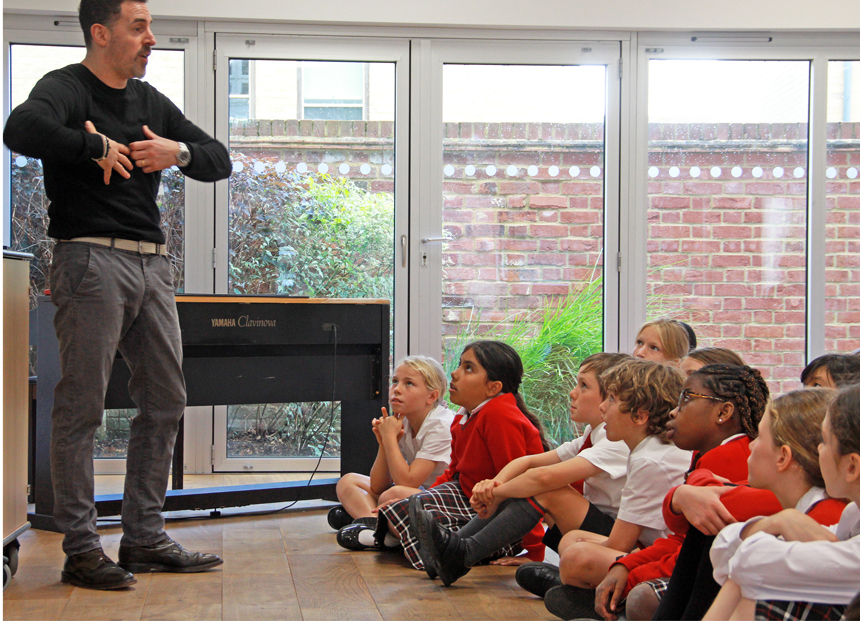 man giving a talk to children in front of an interactive board