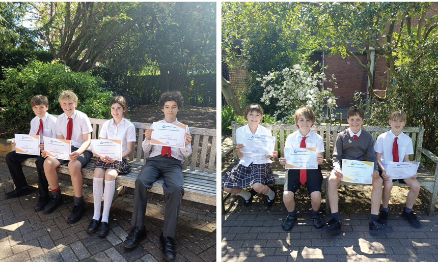 children sitting on a bench holding up winning certificates