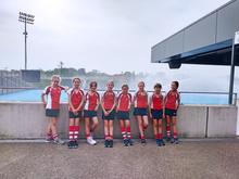 Girls standing in a row in their hockey kit after a match