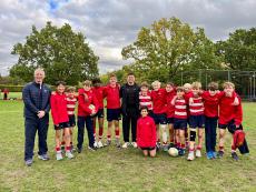 boys standing on a rugby pitch with rugby player