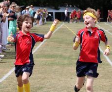 two boys crossing the finishing line on a race