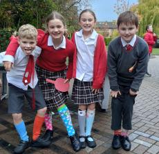 four children wearing odd socks and smiling in a playground