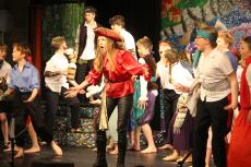 children dressed in pirates costumes acting on a stage