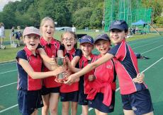girls on athletics track with trophy