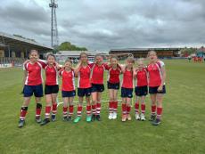 girls standing on a football pitch