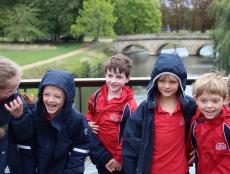 children standing outside on a bridge over a river