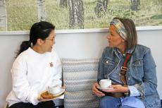 two women sitting on a sofa chatting