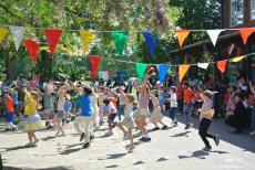 Children folk dancing under bunting