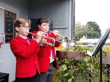 Two children standing playing the trumpet