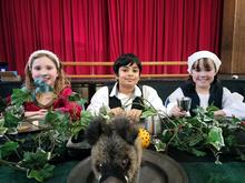 Three children dressed in Tudor costume sitting at a table