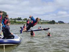 Children jumping off a canoe having fun