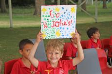 a child holding a sign saying 'Go St John's'