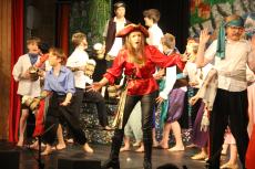 children acting on a stage dressed in pirates costumes