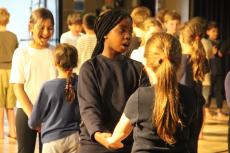 2 children holding hands singing