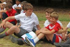 boys smiling and chatting on the grass
