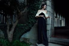 woman in a dark castle cellar looking down a corridor