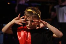 boy with hands over his face dressed as a roman