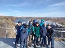 a group of children posing for a photo in front of a glacier in Iceland