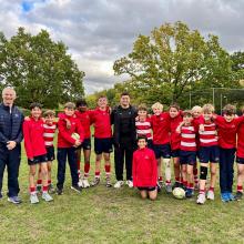 boys standing on a rugby pitch with rugby player
