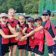 girls on athletics track with trophy