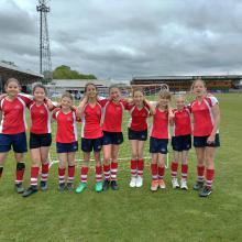 girls standing on a football pitch