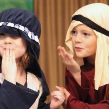 two children performing a nativity on stage