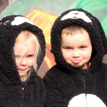 two young children standing on a stage dressed in cow outfits