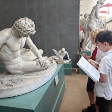 children looking at an ancient greek statue at a museum