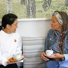 two women sitting on a sofa chatting