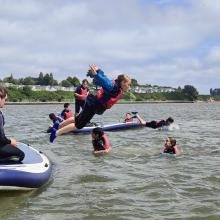 Children jumping off a canoe having fun