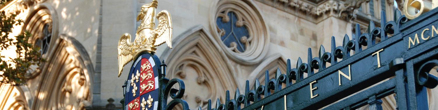 Gold eagle and crest above black iron gates