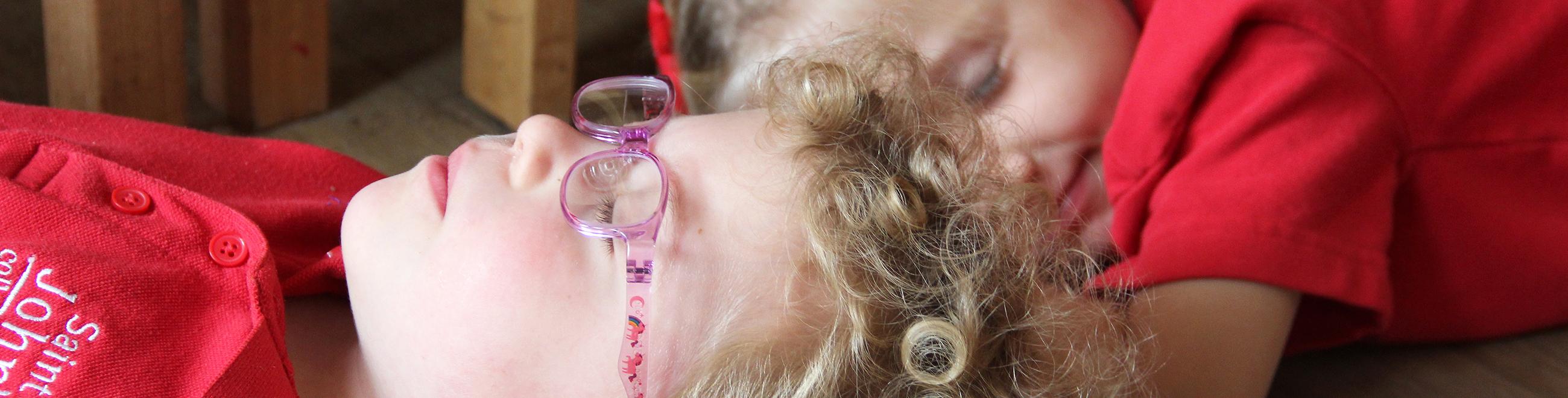 children lying on the floor with their eyes closed practising mindfulness