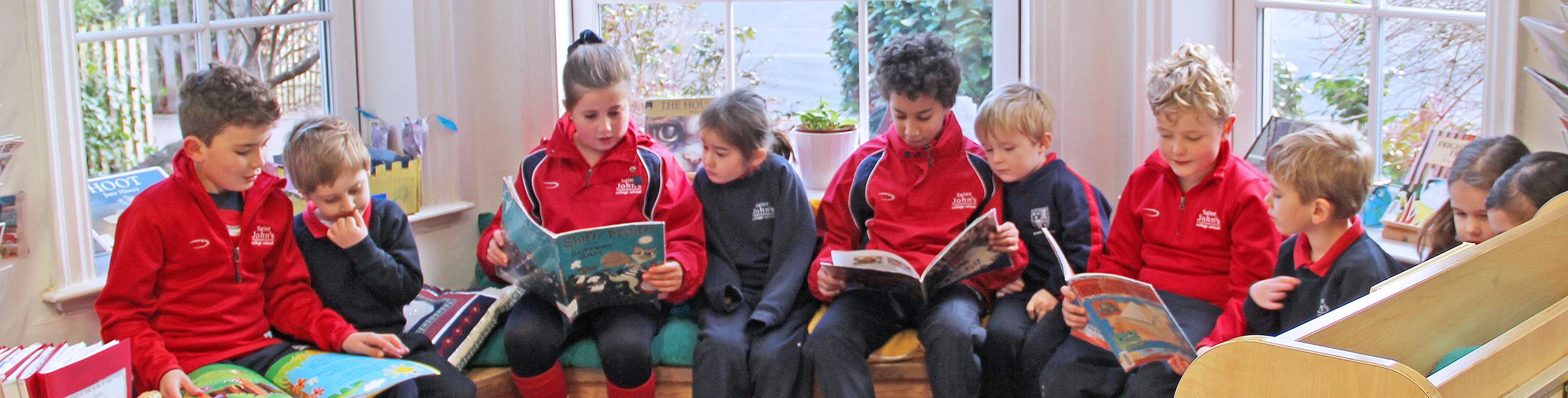 children sitting in pairs reading to each other